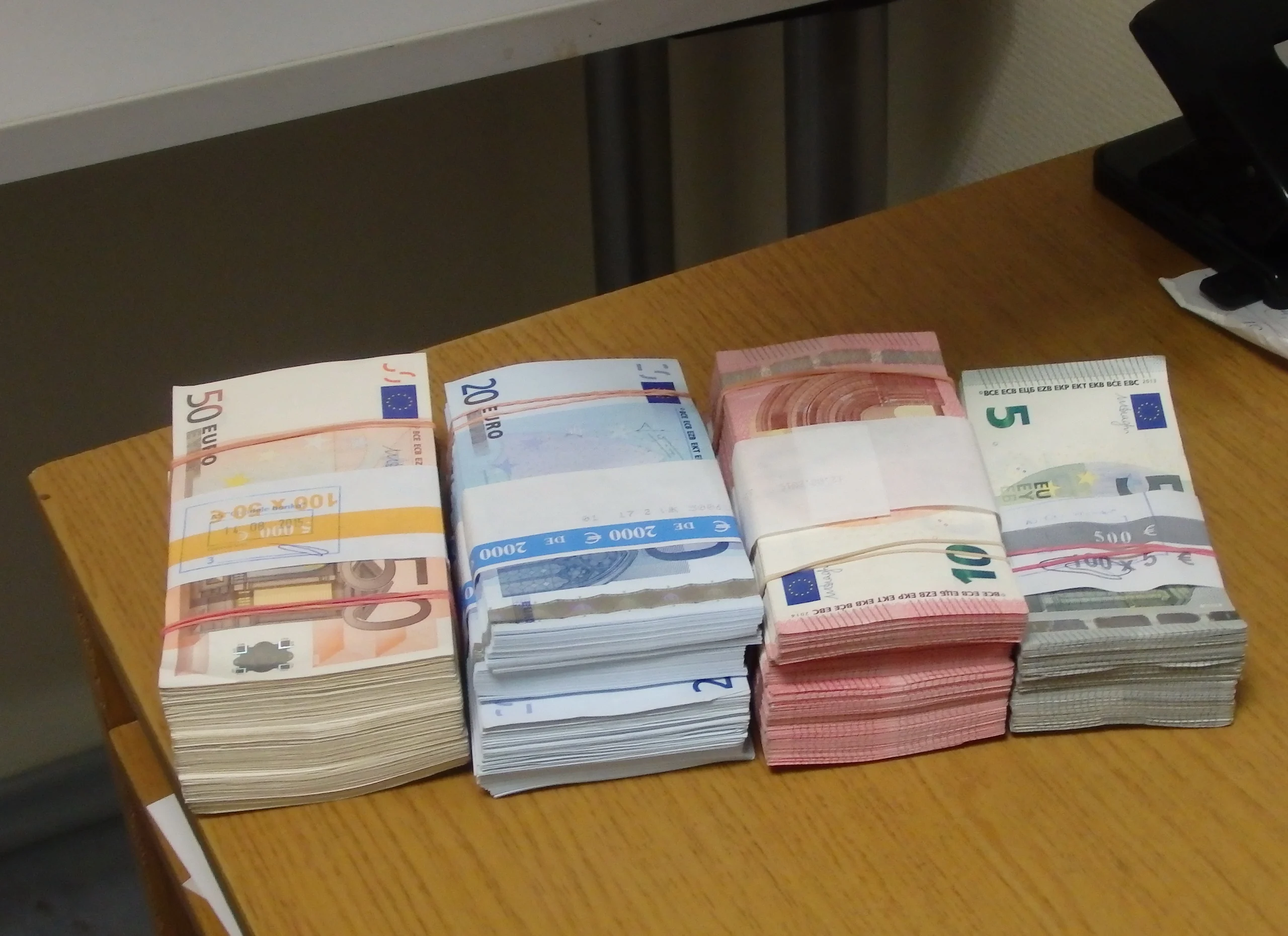 Maços de notas de cinco, dez, vinte e cinquenta euros sobre uma mesa