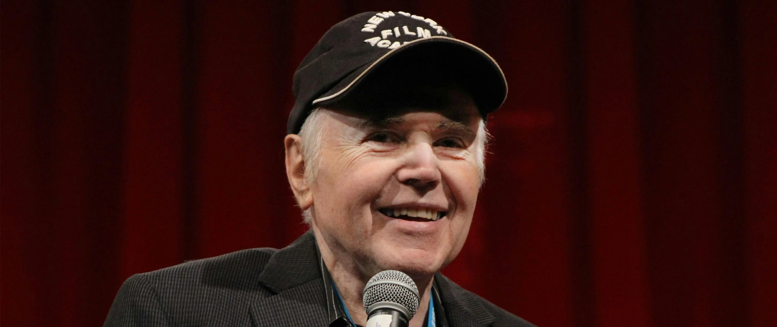 Walter Koenig em evento público, usando boné e segurando um microfone durante encontro com fãs