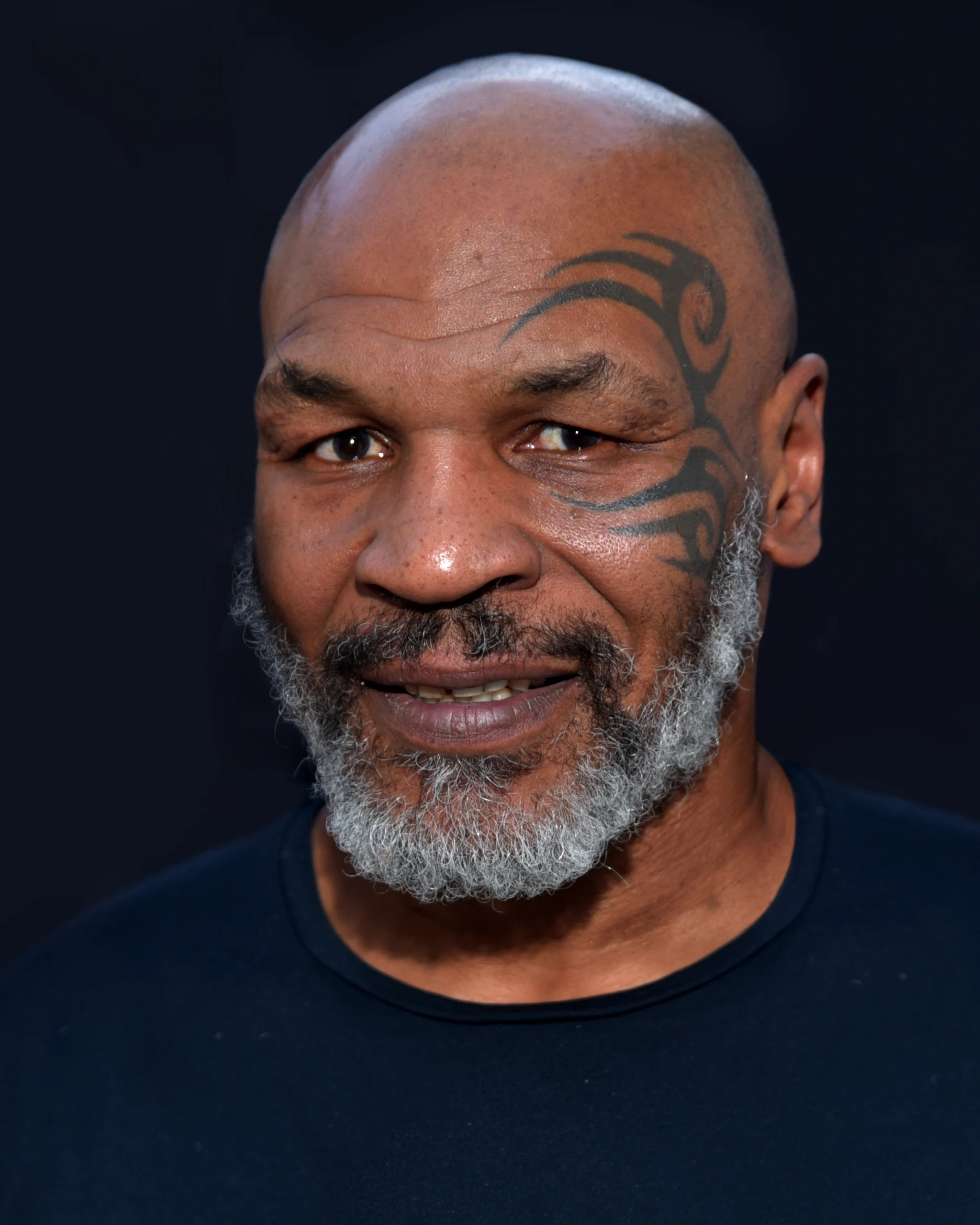 Mike Tyson em retrato de 2019, com a tatuagem no rosto e barba grisalha