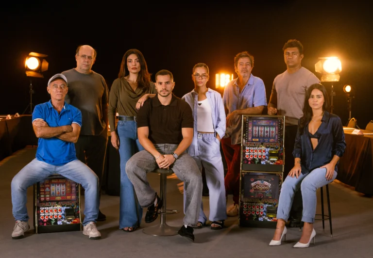 Elenco da série Os Donos do Jogo reunido ao redor de máquinas caça-níqueis em imagem oficial da Netflix