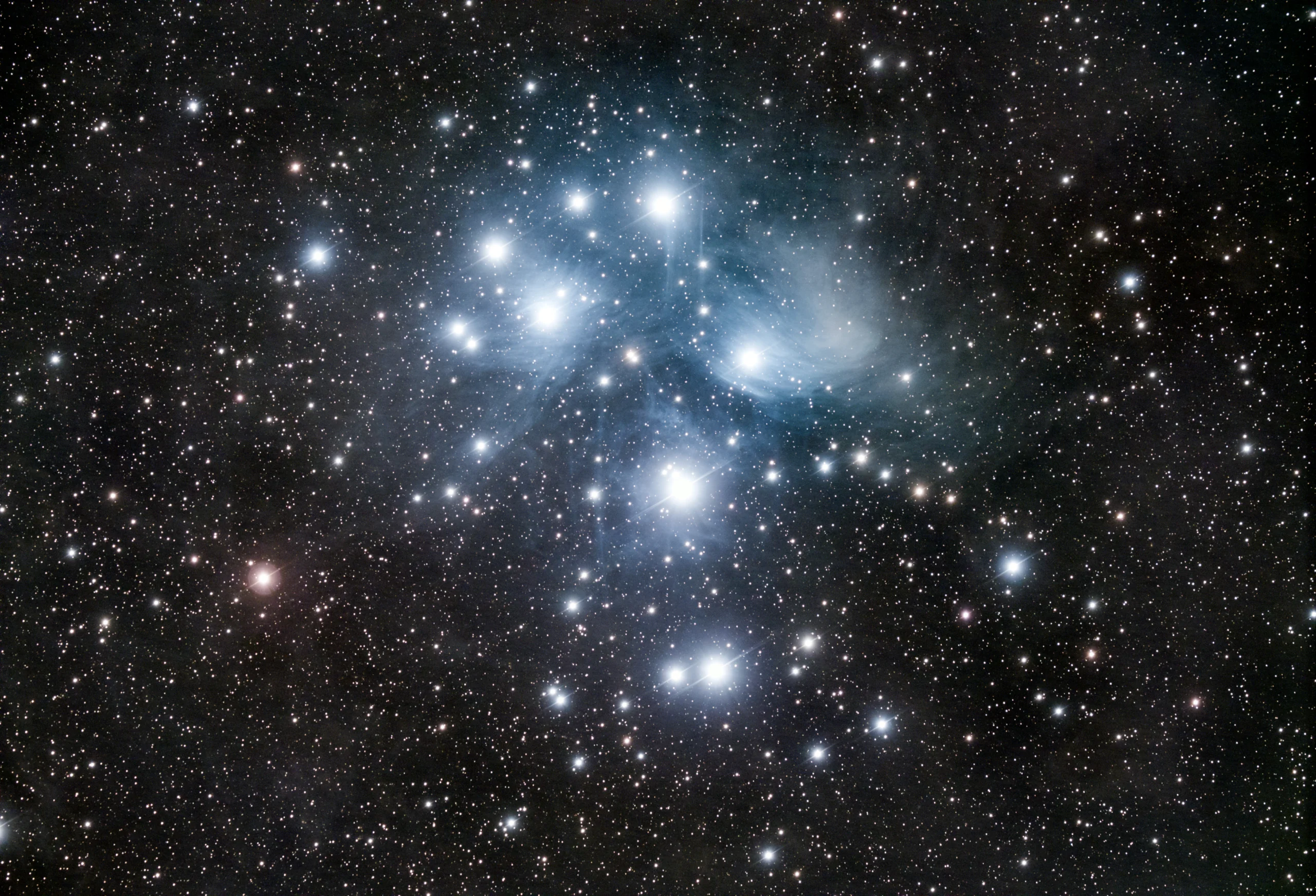 Registro astronômico das Plêiades com várias estrelas concentradas na região do aglomerado M45