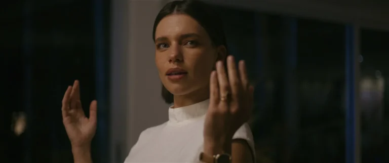 Bruna Linzmeyer como Virgínia Heinzel levanta as mãos em cena de Virtuosas