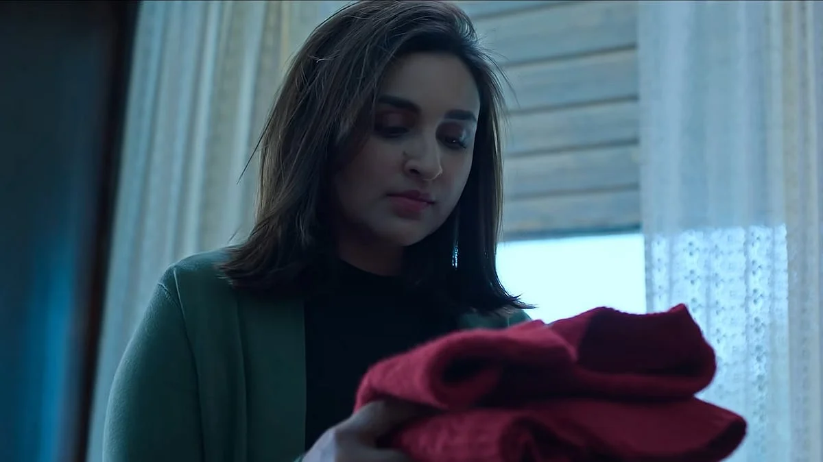 Parineeti Chopra observa uma peça de roupa vermelha em cena de Instinto de Mãe