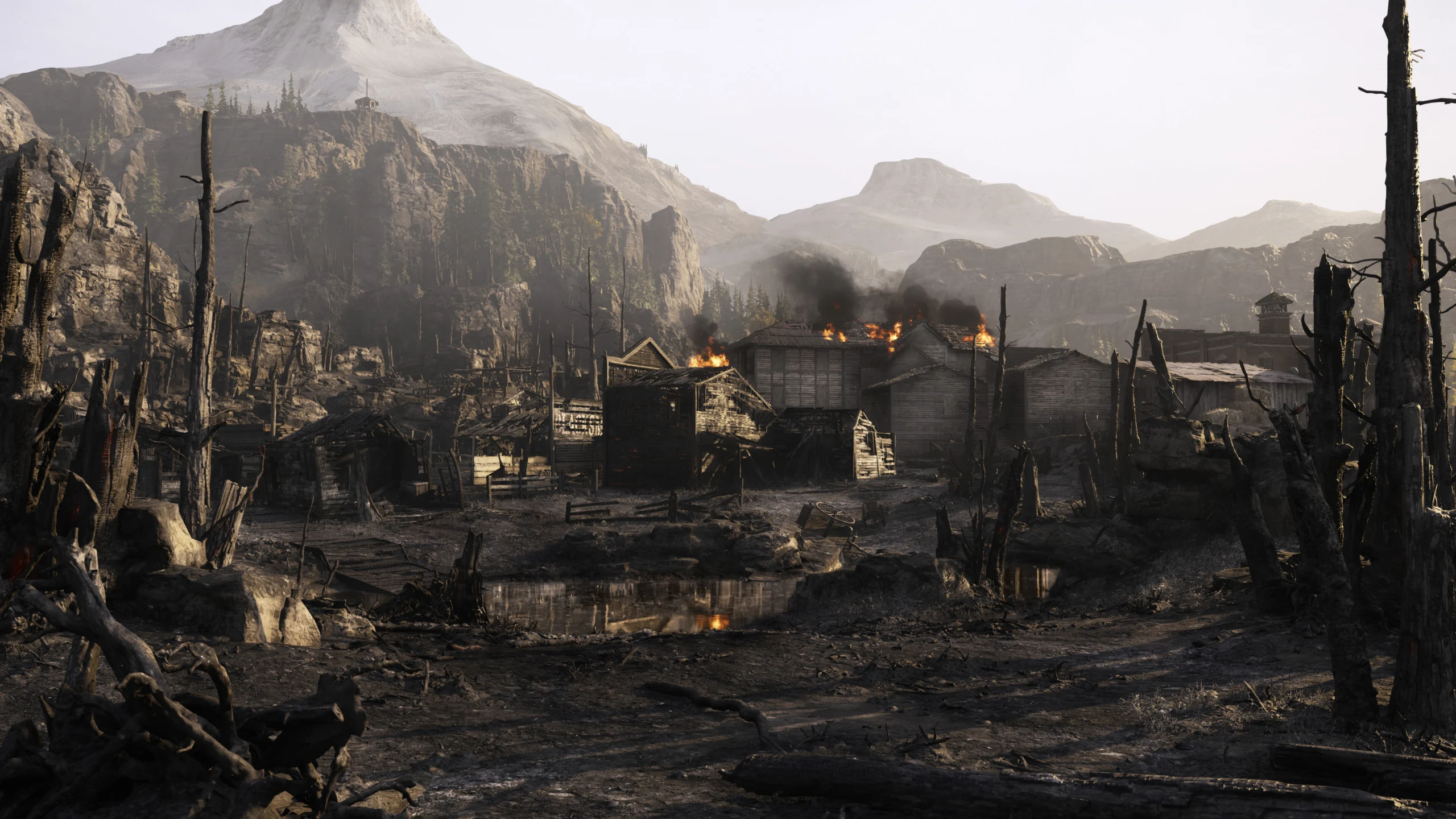 Construções de madeira em chamas cercadas por árvores queimadas e montanhas em Hunt: Showdown 1896.