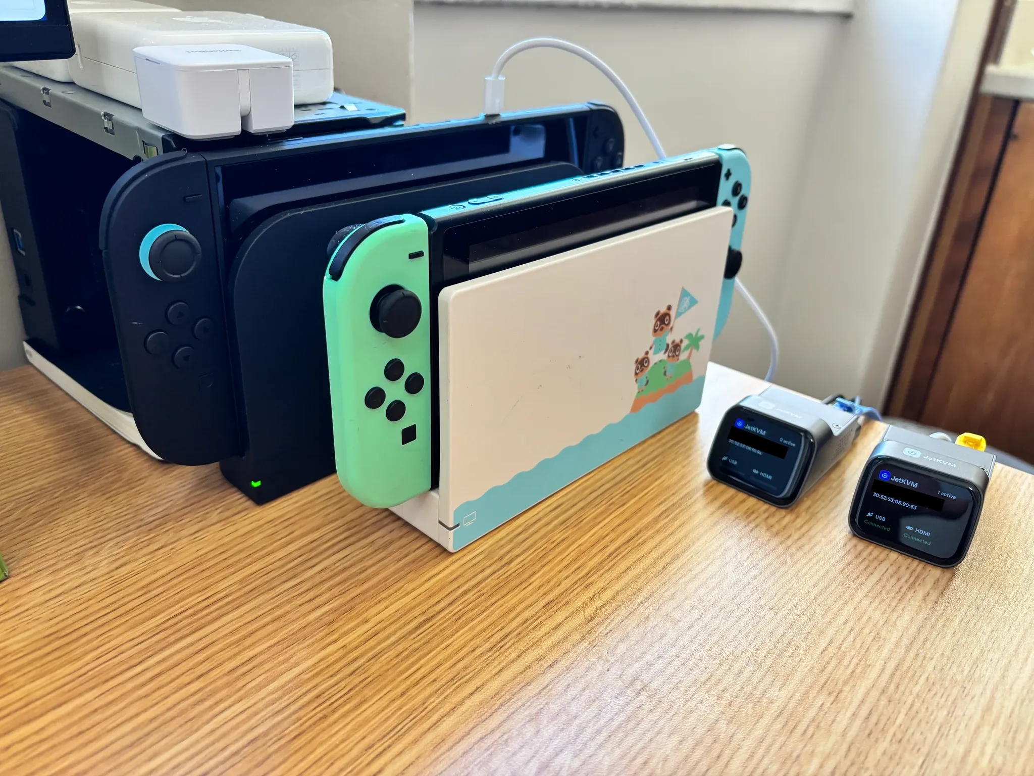 Bancada de pesquisa com Nintendo Switch original, Switch 2 e equipamentos de teste JetKVM
