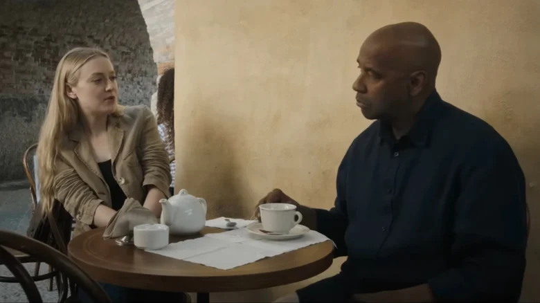 Emma Collins, interpretada por Dakota Fanning, conversa com Robert McCall à mesa de um café