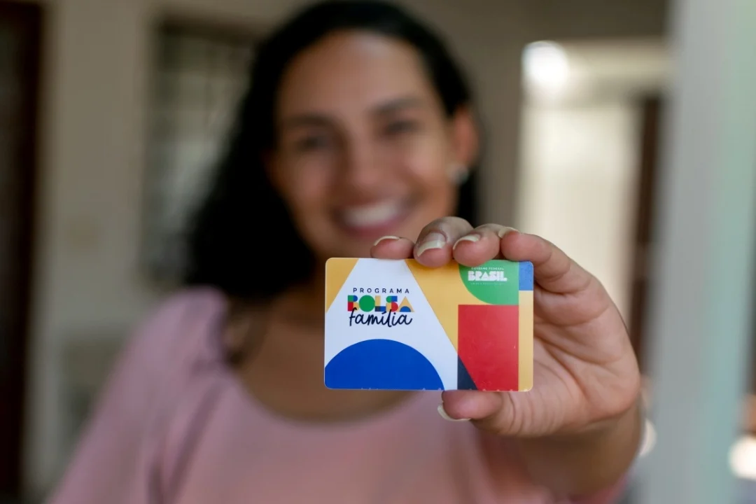 Beneficiária mostra o cartão oficial do programa Bolsa Família