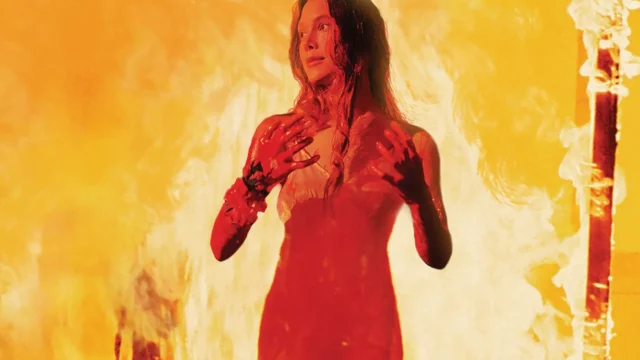 Sissy Spacek como Carrie White, coberta de sangue e cercada por chamas no filme de 1976