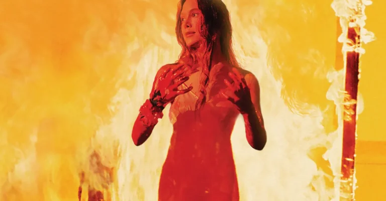 Sissy Spacek como Carrie White, coberta de sangue e cercada por chamas no filme de 1976
