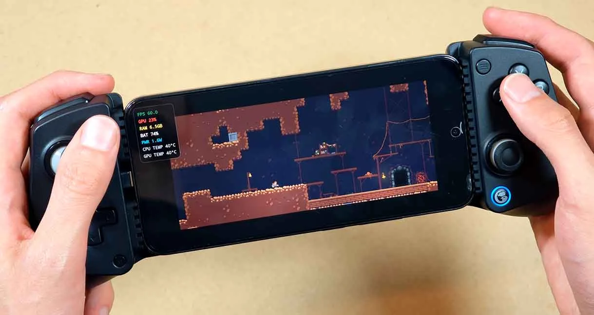 Pessoa segurando um celular Xiaomi 14 com controle acoplado enquanto Caveblazers é executado pelo GameNative com informações de desempenho na tela