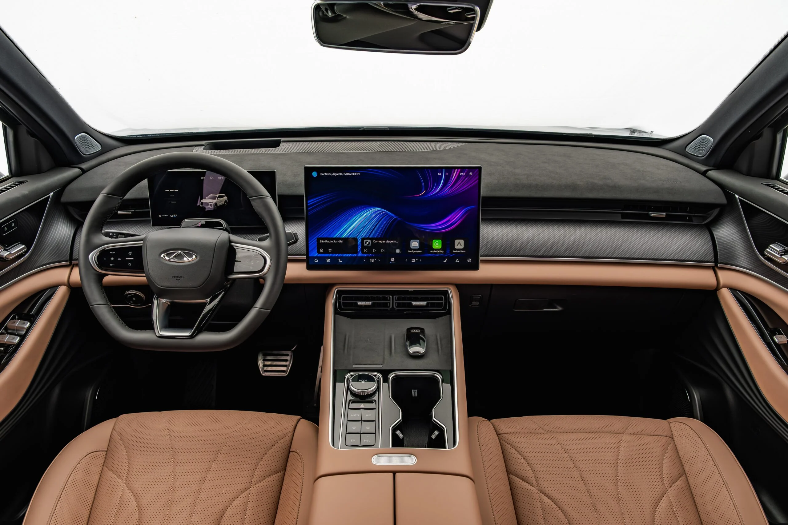 Interior do CAOA Chery Tiggo 9 com bancos marrons, painel digital e central multimídia
