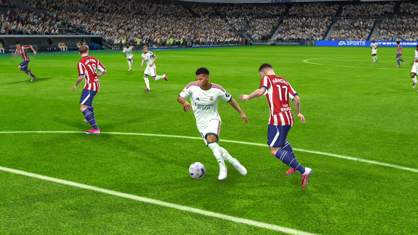 Jogador do Real Madrid cercado por defensores do Atlético de Madrid no FC Mobile