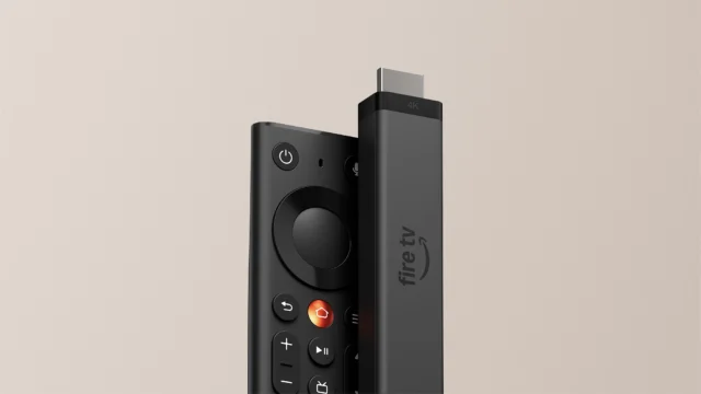 Novo Fire TV Stick 4K de 2026 ao lado do controle remoto Fire TV, sobre fundo bege