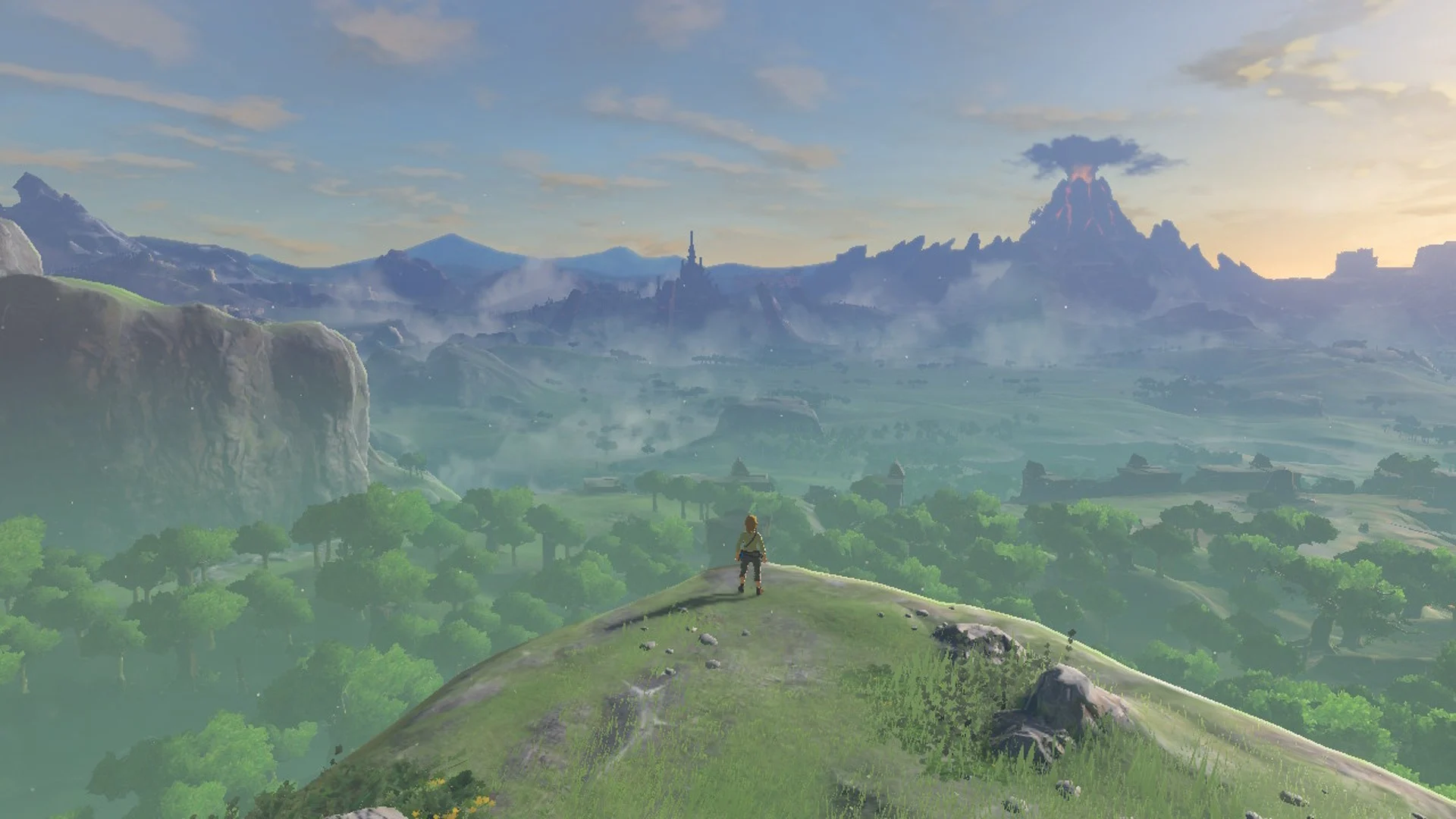 Link observa o vasto mundo de Hyrule em The Legend of Zelda Breath of the Wild, com montanhas, florestas e castelo ao fundo