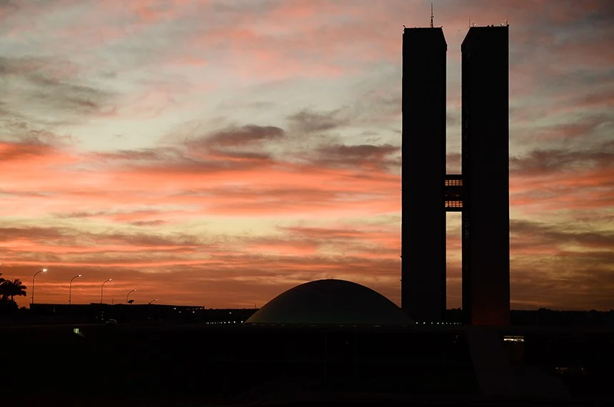 Silhueta do Congresso Nacional e das torres do Senado ao pôr do sol