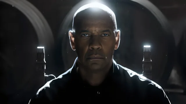 Denzel Washington como Robert McCall, sentado e olhando à frente em O Protetor: Capítulo Final