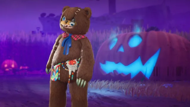 HamiKuma, urso de pelúcia com costuras e doces, diante de uma abóbora iluminada na loja oficial do Fortnite