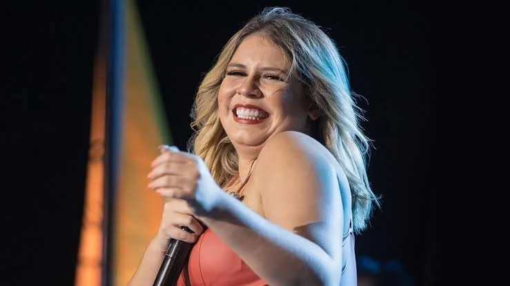 Marília Mendonça canta e sorri durante uma apresentação ao vivo