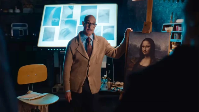 Stanley Tucci exibe uma pintura da Mona Lisa em cena do filme Plano Mestre