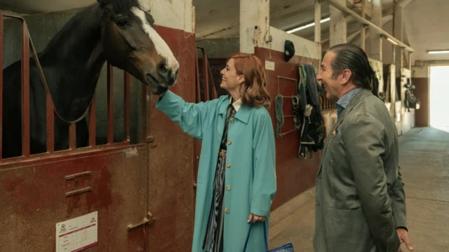 Sofía e Leandro visitam uma área de estábulos com um cavalo.