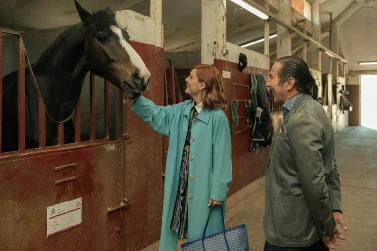 Sofía e Leandro visitam uma área de estábulos com um cavalo.