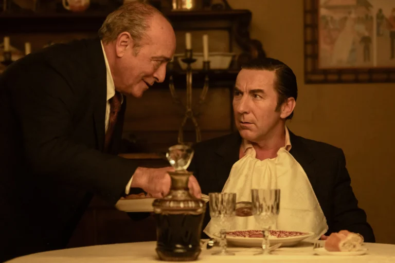 Leandro e um homem mais velho conversam à mesa durante uma refeição.