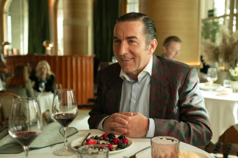 Leandro sorri sentado à mesa de um restaurante.