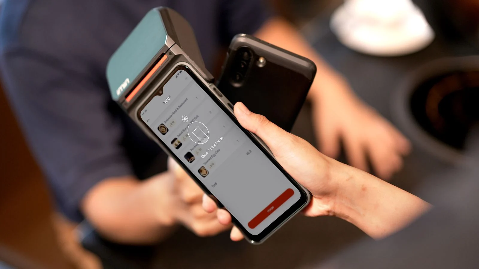 Smartphone próximo de terminal compatível com tecnologia NFC para pagamento