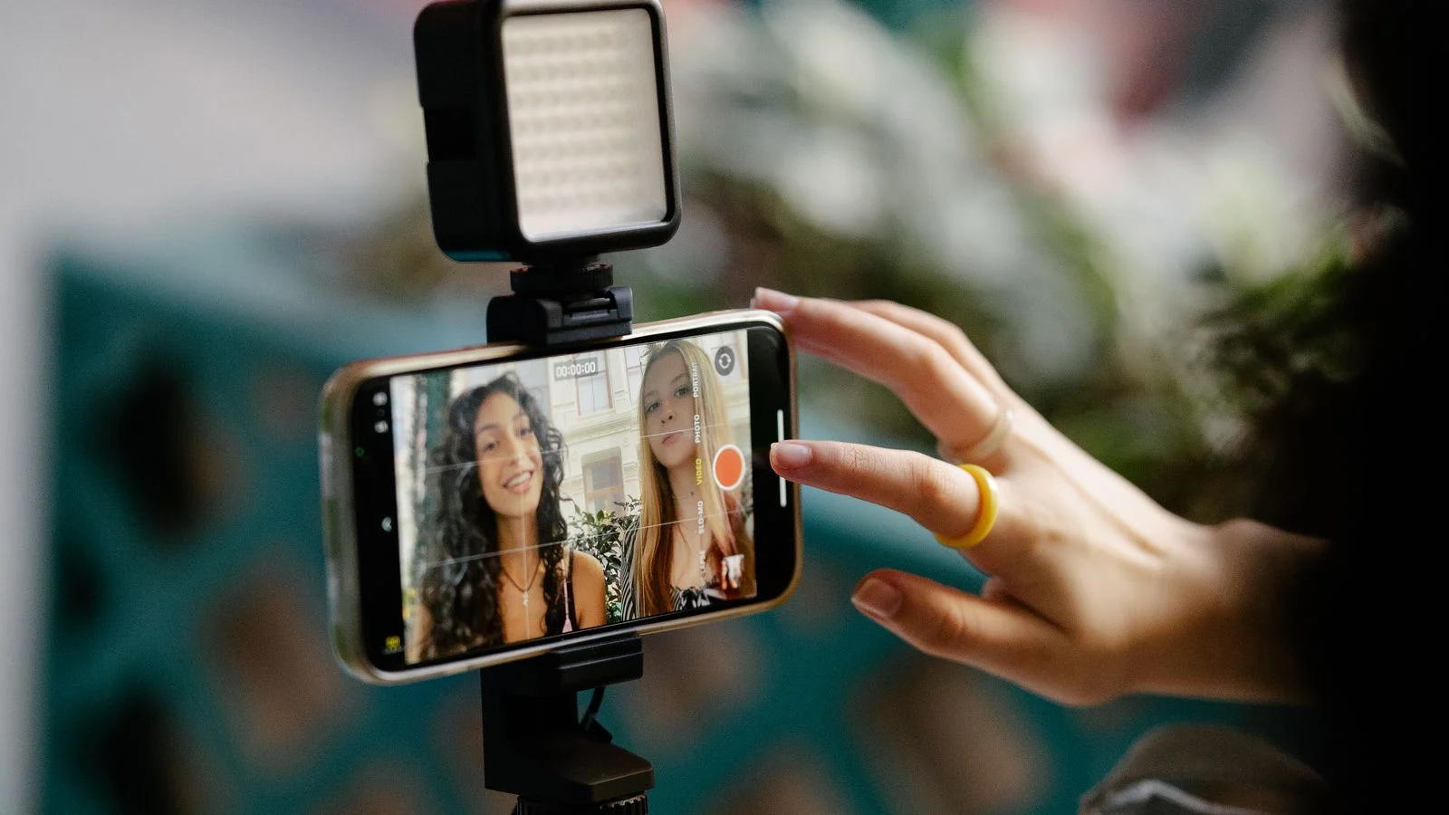 Criadoras de conteúdo gravam um vídeo usando smartphone e iluminação para redes sociais