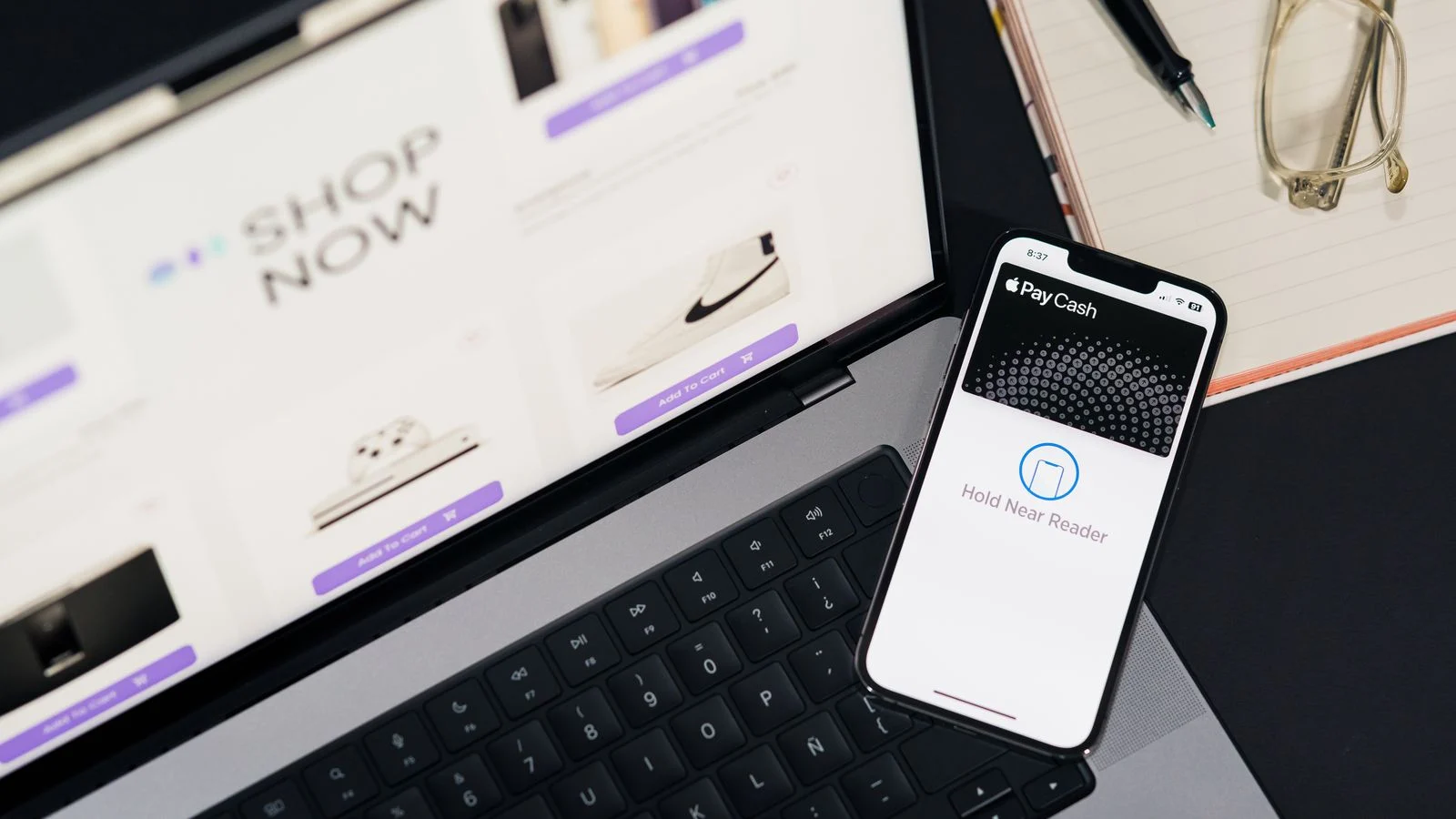 Notebook e celular sobre mesa representando compras online e pagamentos digitais