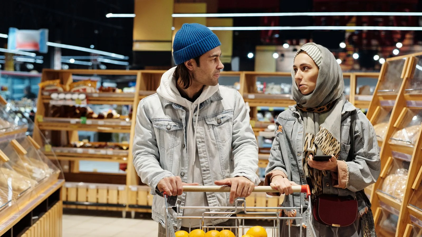 Casal faz compras em supermercado e observa produtos nas prateleiras