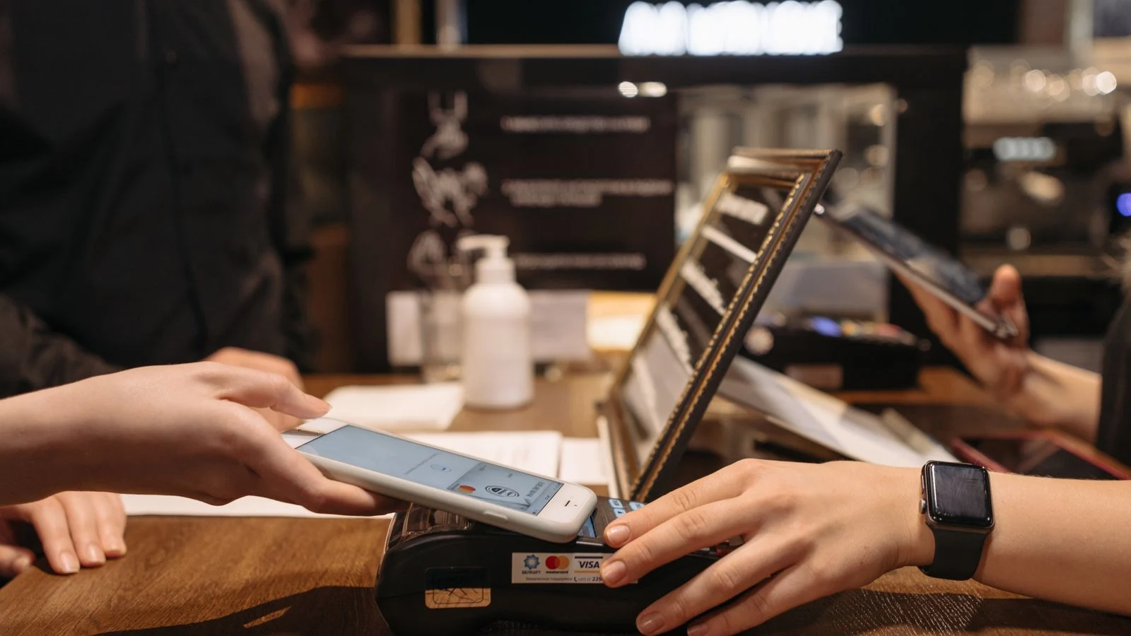 Pessoa aproxima celular de uma maquininha para realizar pagamento por aproximação
