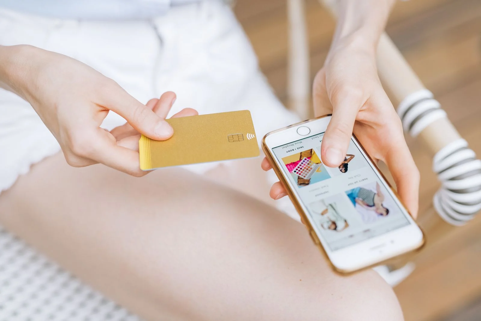 Pessoa segurando celular e cartão durante uma compra pela internet