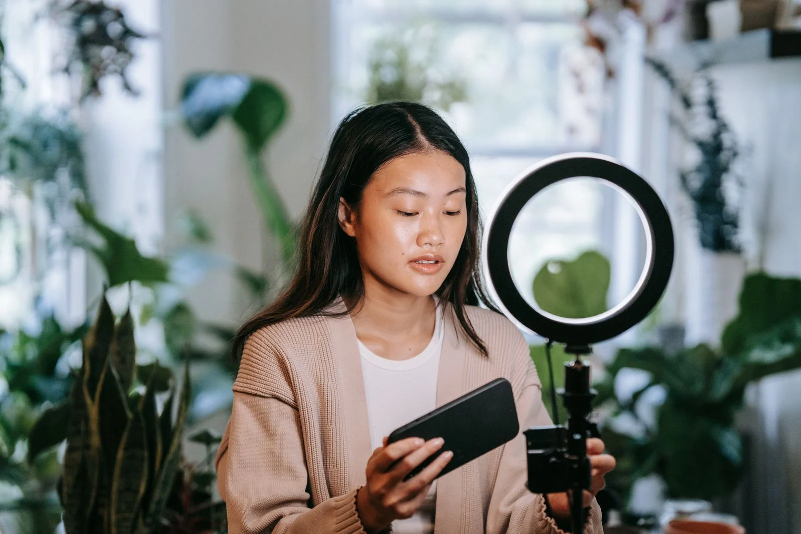Pessoa ajusta o smartphone junto a uma iluminação circular antes de gravar conteúdo