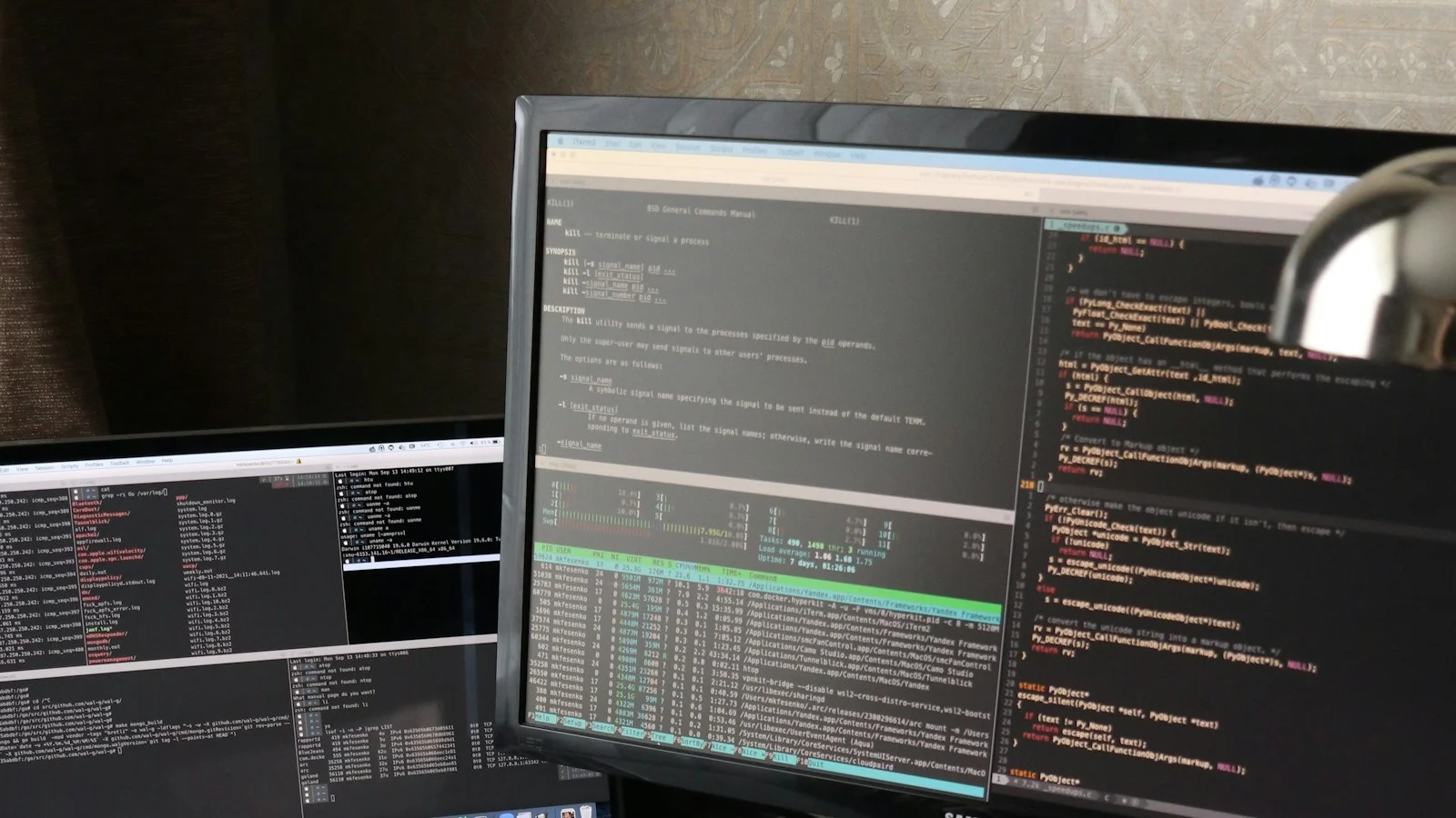 Mesa de trabalho com notebook e monitor usados para programação e tarefas digitais