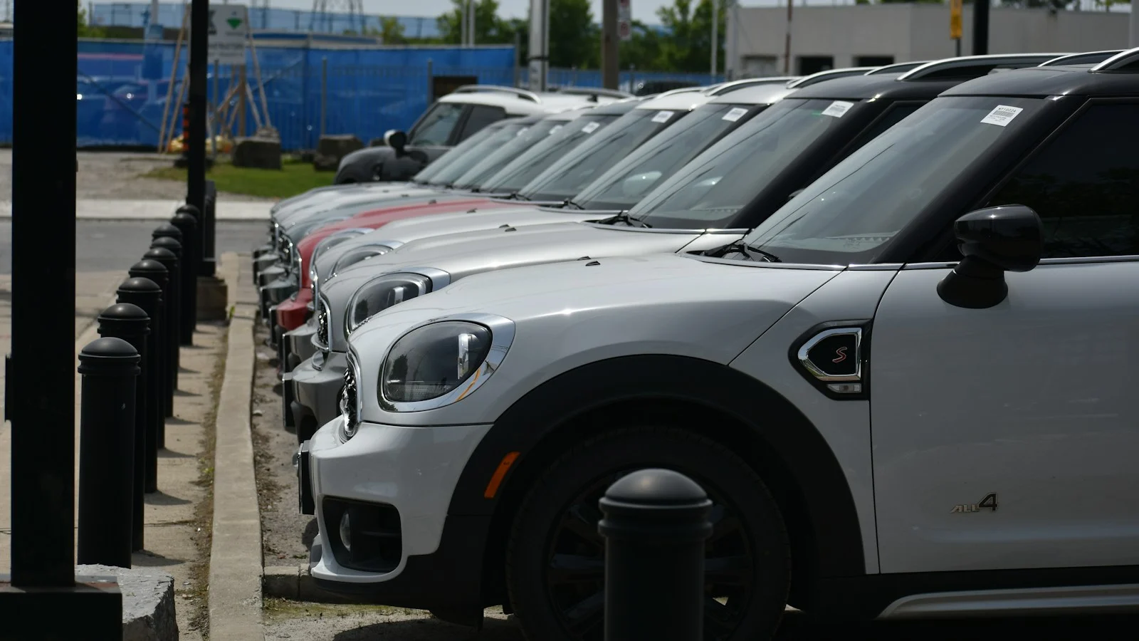Carros estacionados em sequência no pátio de uma loja de veículos