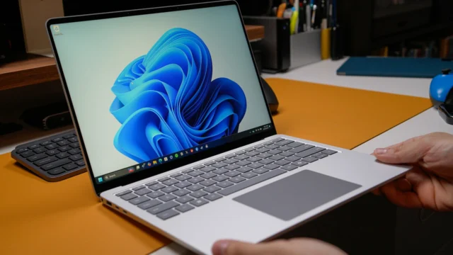 Notebook com Windows 11 aberto sobre uma mesa, ilustrando o desligamento automático do PC