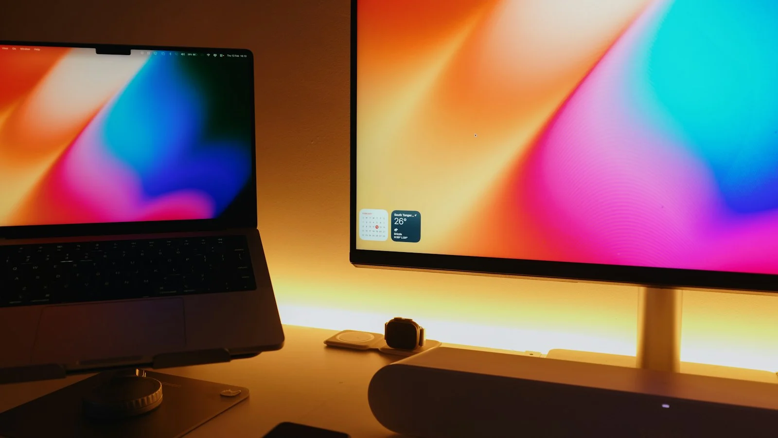 Notebook e monitor em uma mesa de trabalho, ilustrando o uso de modelos de IA local em diferentes computadores