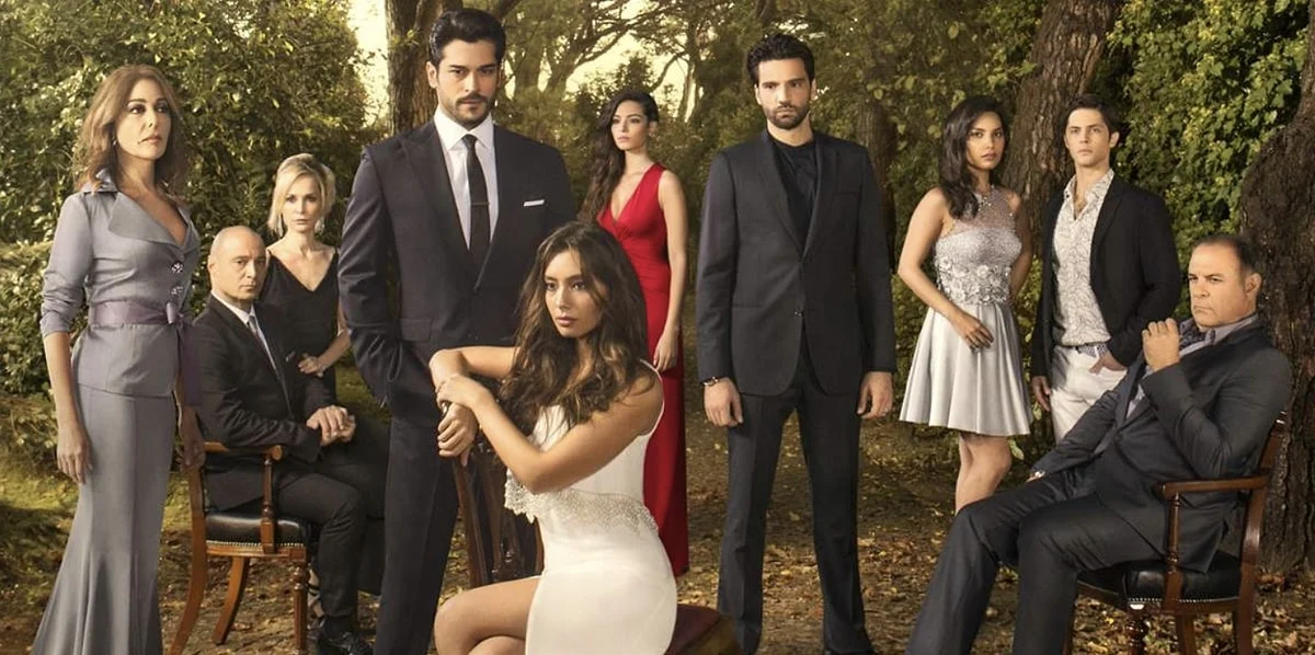 Elenco de Kara Sevda reunido em fotografia promocional com os protagonistas e familiares