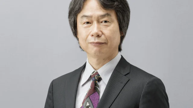 Shigeru Miyamoto sorri em um retrato de arquivo, vestindo camisa clara.