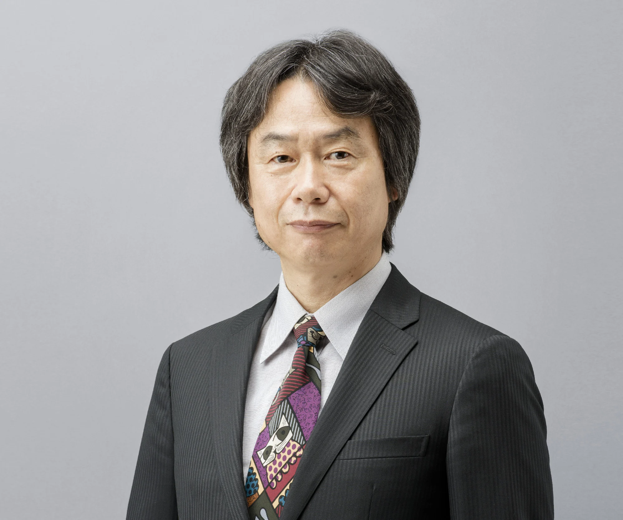 Shigeru Miyamoto sorri em um retrato de arquivo, vestindo camisa clara.