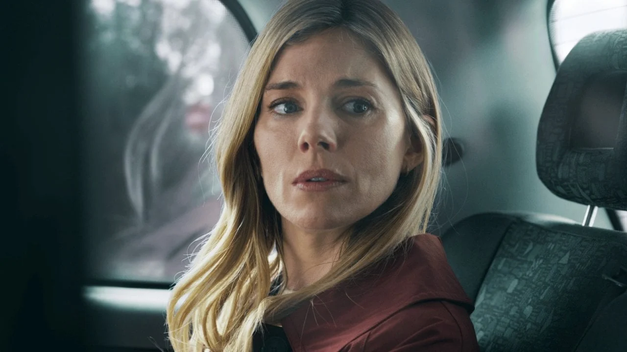 Sienna Miller como Carla Duval dentro de um carro em cena da série Guerra