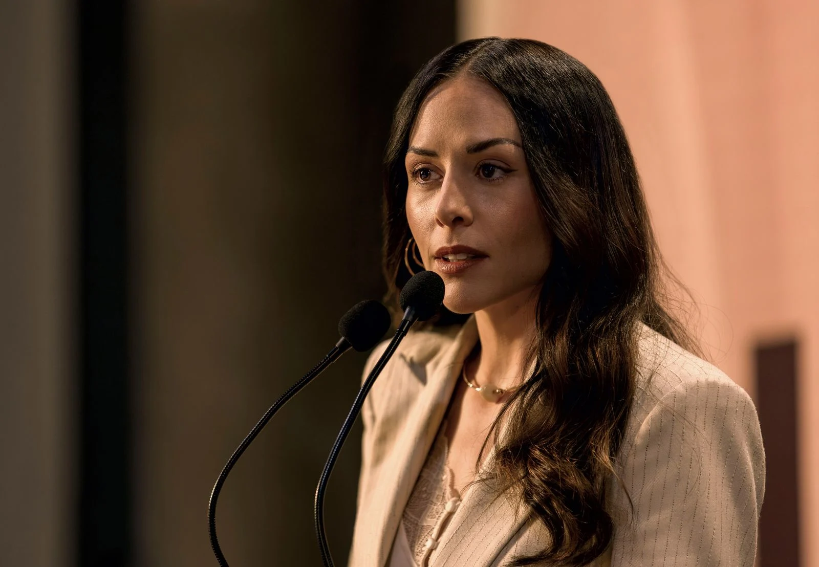 Zuria Vega como Amelia Navarro discursando diante de microfones em Dentro do Círculo